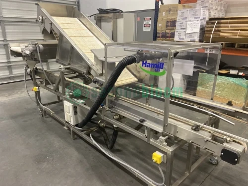 Hamill Aqua Adjustable 18-24” Aquaponics Harvester loaded with trays of baby leaf greens in an aquaponics facility, showcasing its open design and adjustable infeed belt ready for high-volume harvesting.