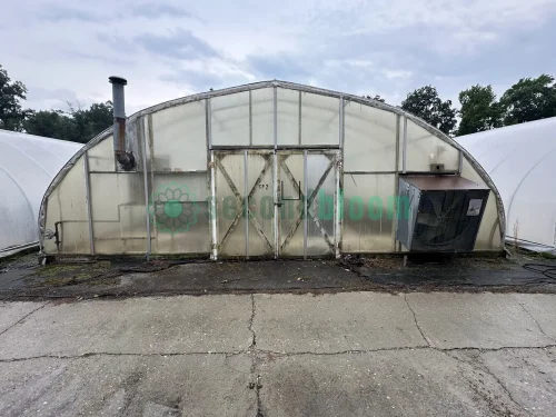 Exterior view of the fan end of the X.S. Smith Quonset Cold Frame greenhouse labeled CF02 at White's Greenhouse Auction on SecondBloom Auctions platform, featuring essential fan equipment.