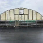 Interior view of the vent end of the X.S. Smith Quonset Cold Frame greenhouse labeled CF03 at White's Greenhouse Auction on SecondBloom Auctions platform, featuring essential vent equipment.