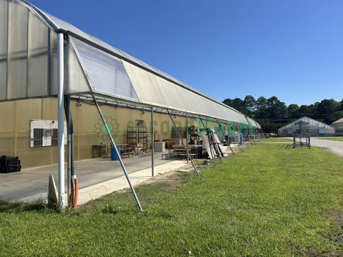 Exterior side view of the greenhouse, illustrating its robust construction and design.