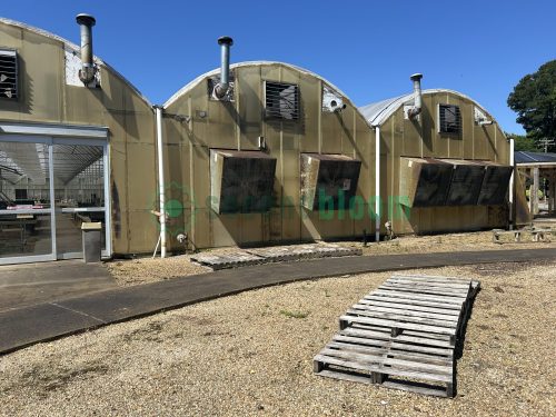 Exterior end view of the greenhouse, highlighting the entrance and overall dimensions.