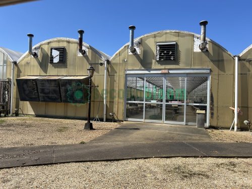 Exterior end view of the greenhouse, highlighting the entrance and overall dimensions.