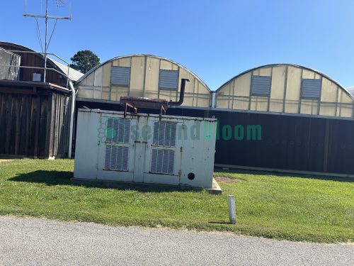Exterior end view of the greenhouse, highlighting the entrance and overall dimensions.