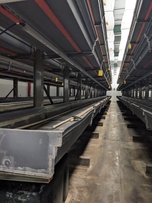 A detailed view of a vertical farm system installed at Your Local Greens in Burlington, North Carolina, featuring multi-level growing trays previously part of the FarmedHere system in Bedford Park, IL.