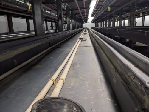 A detailed view of a vertical farm system installed at Your Local Greens in Burlington, North Carolina, featuring multi-level growing trays previously part of the FarmedHere system in Bedford Park, IL.