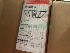 Four brand new Fluence SPYDR 2i high-performance LED grow light fixtures in original packaging, showing ultra-slim 1.3-inch profile design with 47-inch length anodized aluminum chassis and detachable power supplies, each unit featuring PhysioSpec Indoor full-spectrum LED arrays for maximum intensity commercial cultivation with CO₂ supplementation capability