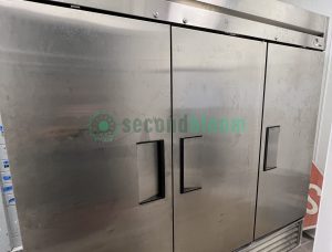 Side view of True 72” Stainless Steel 3-Door Freezer in a commercial kitchen.