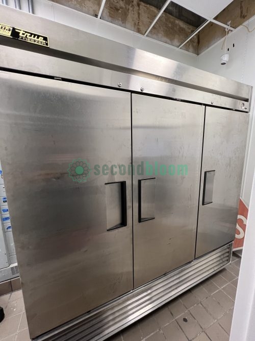 Side view of True 72” Stainless Steel 3-Door Freezer in a commercial kitchen.