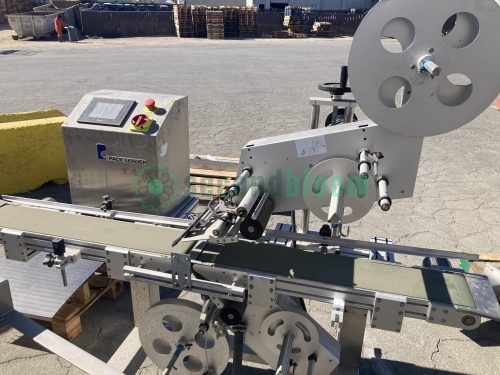 Close-up view of a Pack Leader PL-221 labeling machine, used in leafy greens packaging, showcasing conveyor belt, labeling mechanism, and control panel near Gonzales, California.