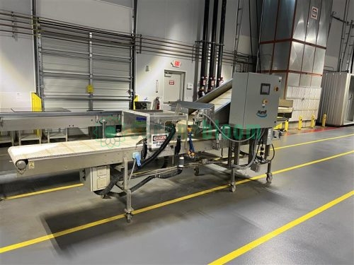 A Hamill microgreens harvester with stainless steel conveyors, operating inside a climate-controlled vertical farming facility for efficient and sustainable indoor crop production.