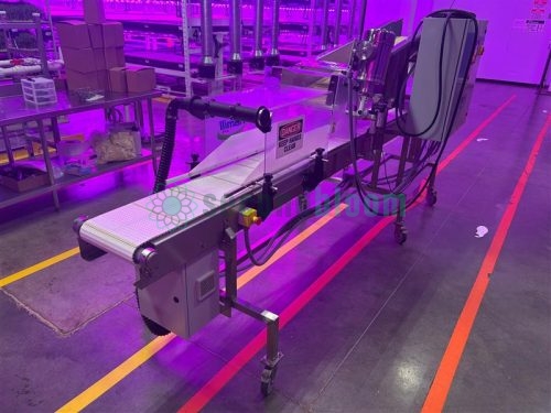 Full conveyor assembly with caution signage and a belt system on a Hamill APS microgreen harvester