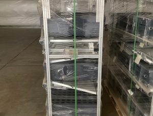 Wrapped Aetrium 2.448 vertical hydroponic tower on wooden pallet showing multi-tier aluminum frame structure with clear plastic protection