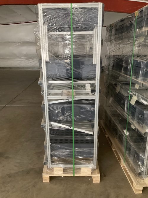 Wrapped Aetrium 2.448 vertical hydroponic tower on wooden pallet showing multi-tier aluminum frame structure with clear plastic protection