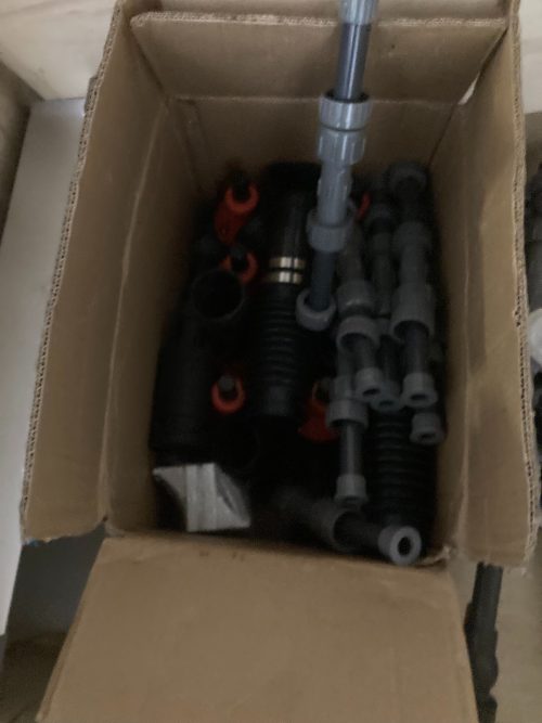 Complex PVC plumbing manifold system with multiple valves and clear monitoring chambers in wooden crate