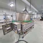 Industrial tray washer with open control panel showing electrical components