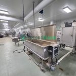Stainless steel industrial tray washer with lid open showing washing chamber interior