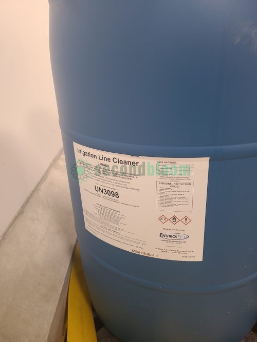 Close-up of EnviroTech Irrigation Line Cleaner drum label showing UN3098 classification and HMIS ratings for CEA system maintenance