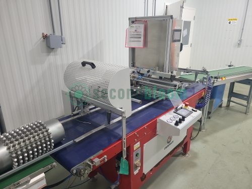 Commercial seeding equipment with perforated metal drum, conveyor system and control panel in vertical farming facility