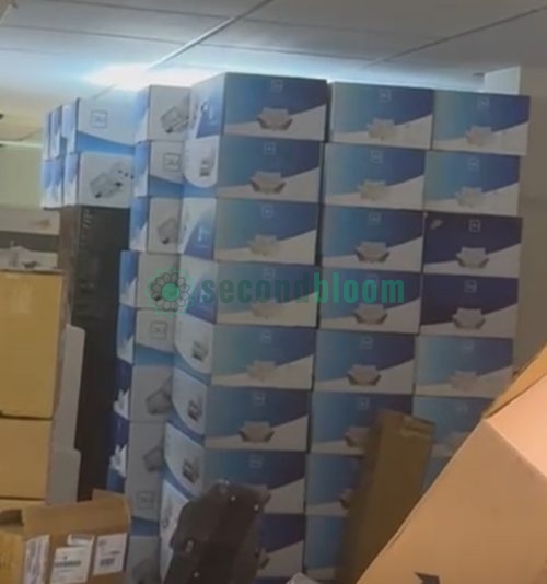 Warehouse storage room with stacked DLI grow light fixture boxes in blue and gray packaging, commercial lighting inventory