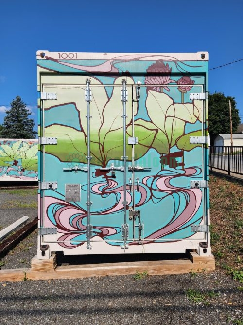 Front view of Freight Farms container unit 1001 showing painted cargo doors with green aquatic plants and pink flower designs on turquoise background