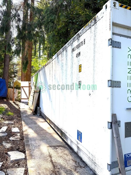 Side view of white Freight Farms Greenery shipping container showing weathered exterior