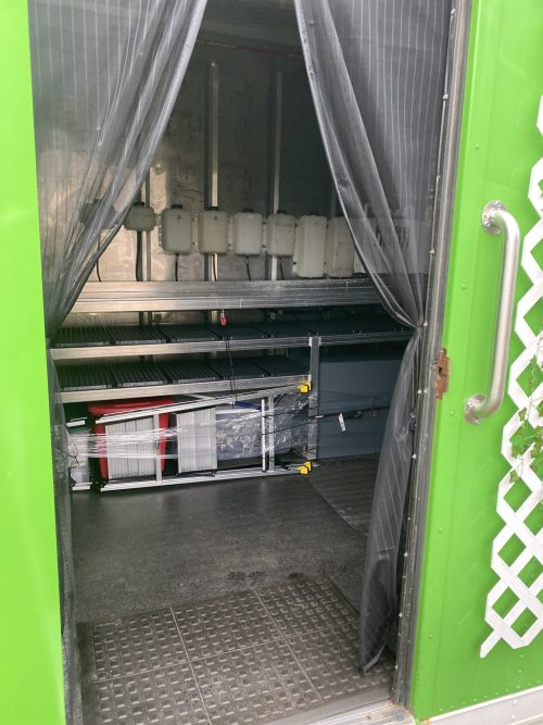 Green Freight Farms shipping container with open door revealing hydroponic growing equipment inside