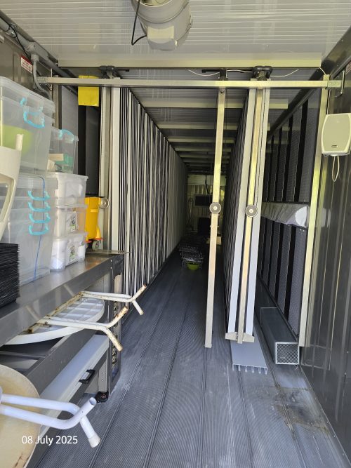 Vertical farming container showing multi-tier growing racks, LED lighting systems, and controlled environment agriculture infrastructure