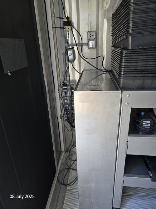 Freight Farms controlled environment agriculture container interior showing advanced control panel, electrical systems, and stainless steel workspace for vertical farming operations