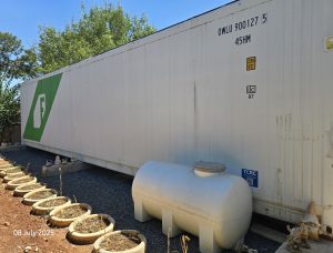 External view of Freight Farms controlled environment agriculture container facility with surrounding growing area for vertical farming