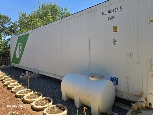External view of Freight Farms controlled environment agriculture container facility with surrounding growing area for vertical farming