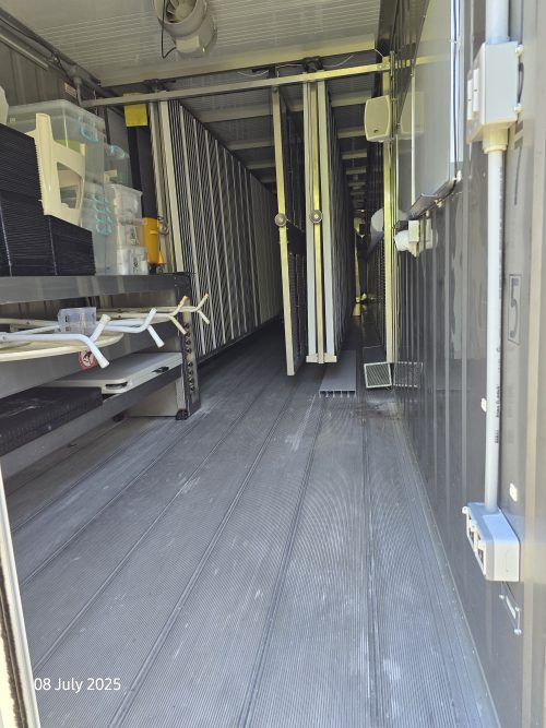 Complete interior view of Freight Farms controlled environment agriculture container showing vertical farming infrastructure and LED systems