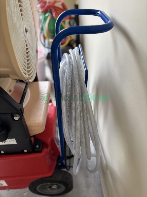 Air hose properly coiled on blue storage hook showing management system